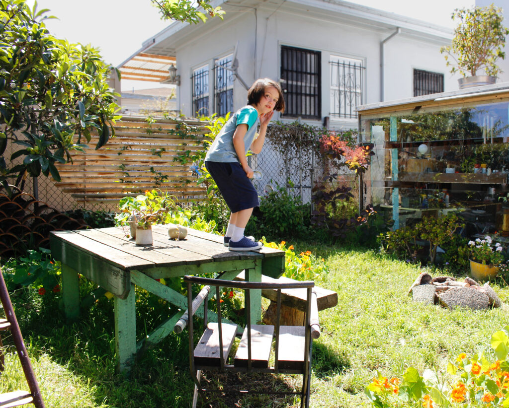 backyard with a child standing on an old wooden table // Casa Nueva by Sky Lanigan
